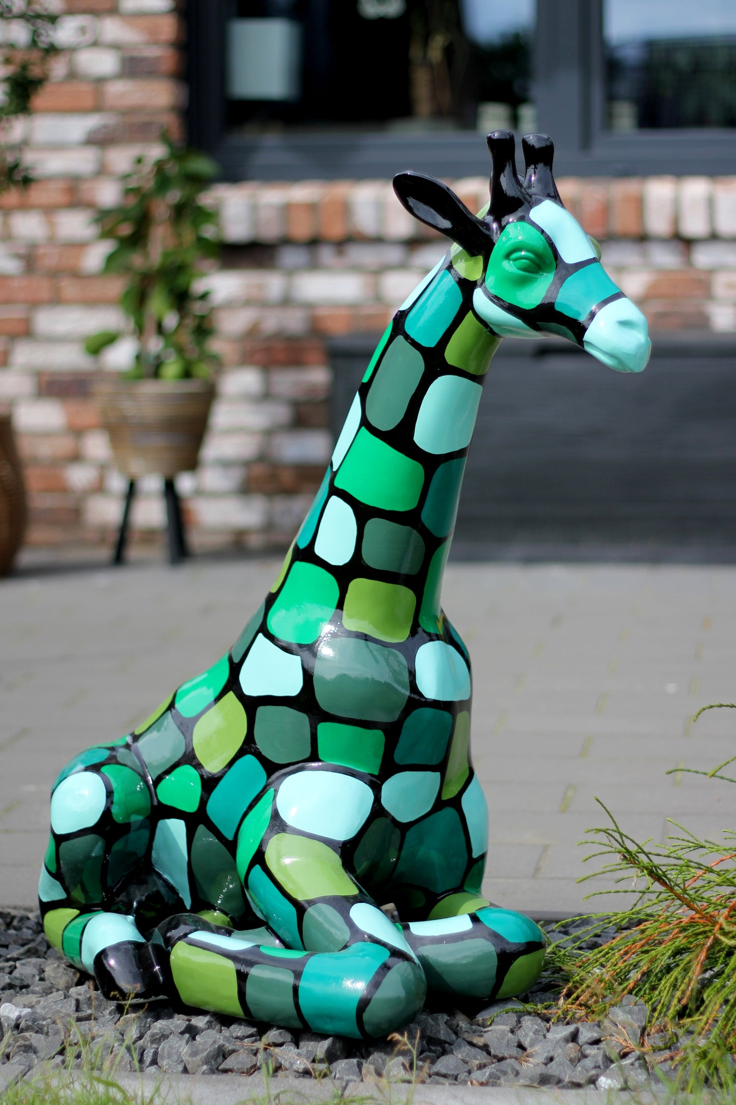 Giraffe sitzend mit grünen Patches aus Kunstharz - 86cm