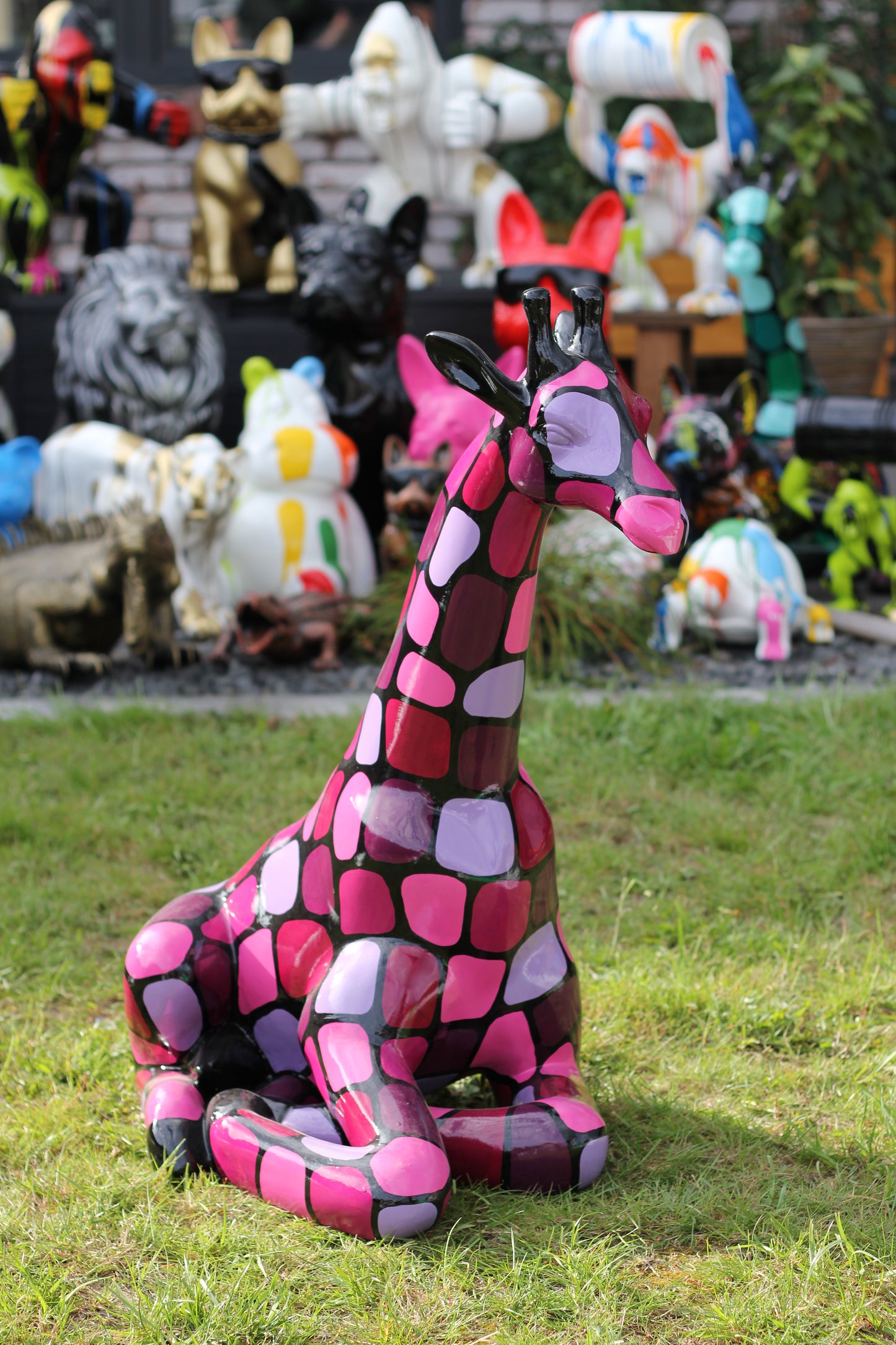Giraffe sitzend mit lilanen Patches aus Kunstharz - 86cm